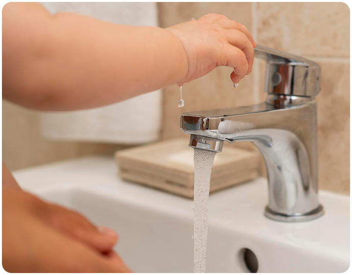 child washing their hands with help parents